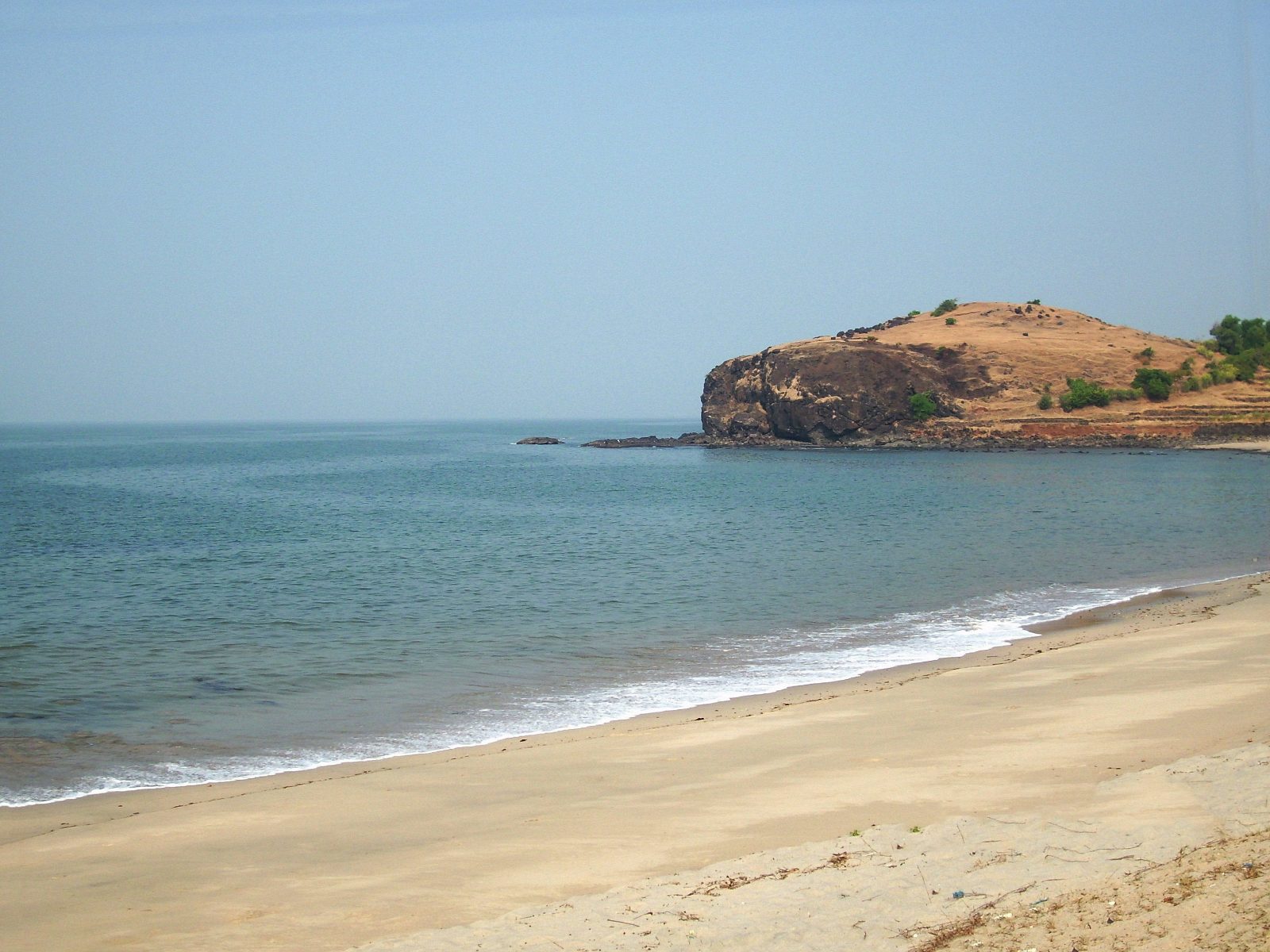 Sandy beach with a rocky headland at Diveagar