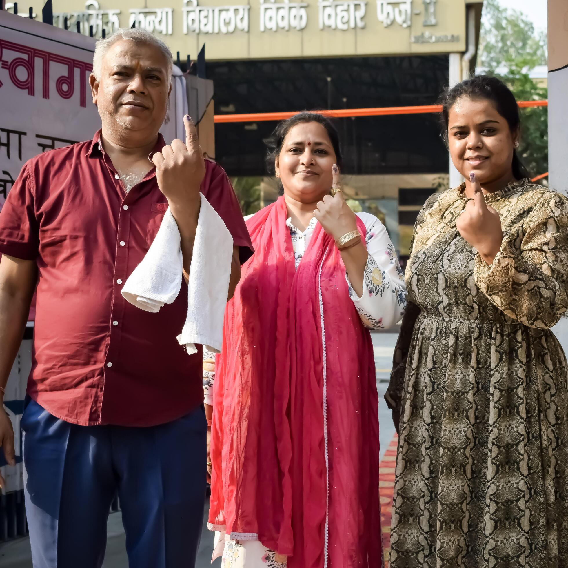 Voters show their ink-marked fingers after casting votes