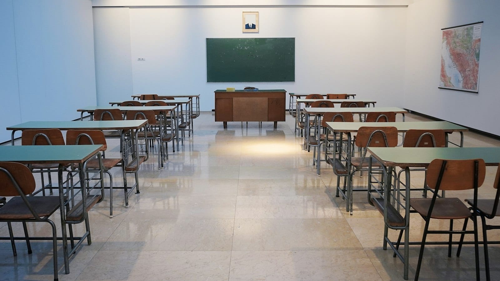 Empty school classroom with desks and chalkboard
