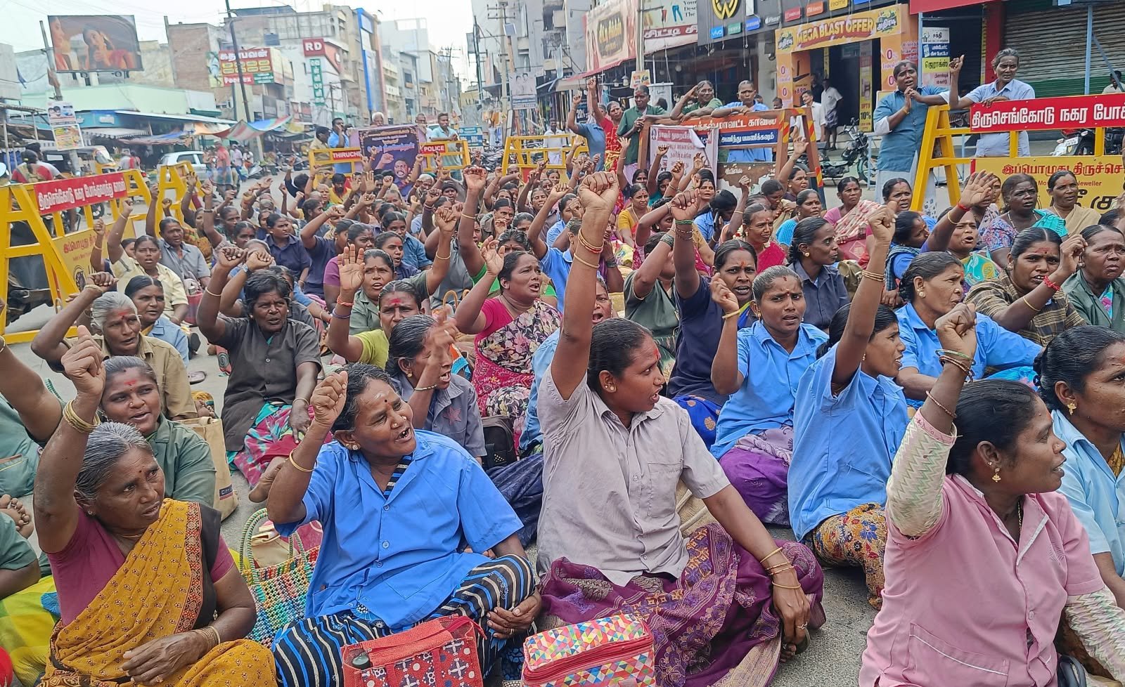 Contract sanitation workers protest with raised fists in front of the Anna statue, Tiruchengode